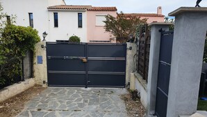 A gated entrance with a stone pathway leading to a building with a tiled roof. - 3 bedroom house 90m² Hyères the sea is 50 meters from the beach (Hyères)