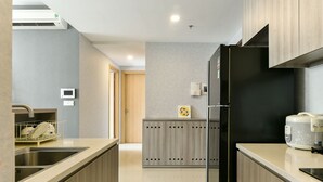 A modern kitchen with a black refrigerator, a dishwasher, and a microwave. - Brian Rivergate Homes (Hồ Chí Minh)