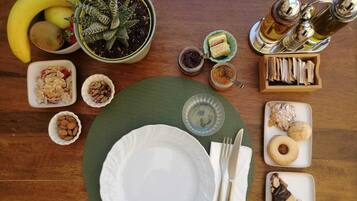 Een tafel gedekt met diverse etenswaren, waaronder fruit, noten en gebak, wat doet denken aan een ontbijt of tussendoortje.