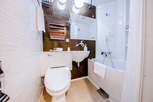 Une salle de bain moderne équipée de toilettes, d’un lavabo et d’une baignoire.