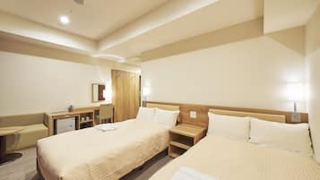 A hotel room with two beds, a desk, a chair, a small table, and a mirror.