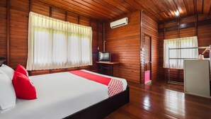 A wooden cabin-style room with a bed, a television, and an air conditioning unit.