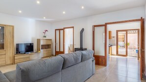 A modern living room with a sofa, TV, wooden cabinet, and a fireplace.