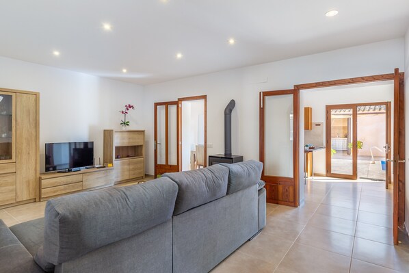 A modern living room with a sofa, TV, wooden cabinet, and a fireplace.