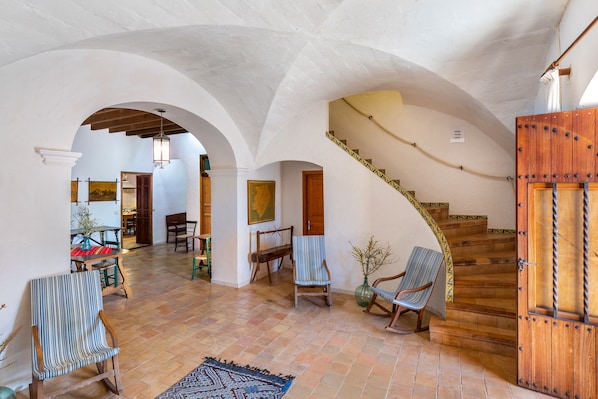 A spacious interior with a staircase, arched ceilings, and a dining area.
