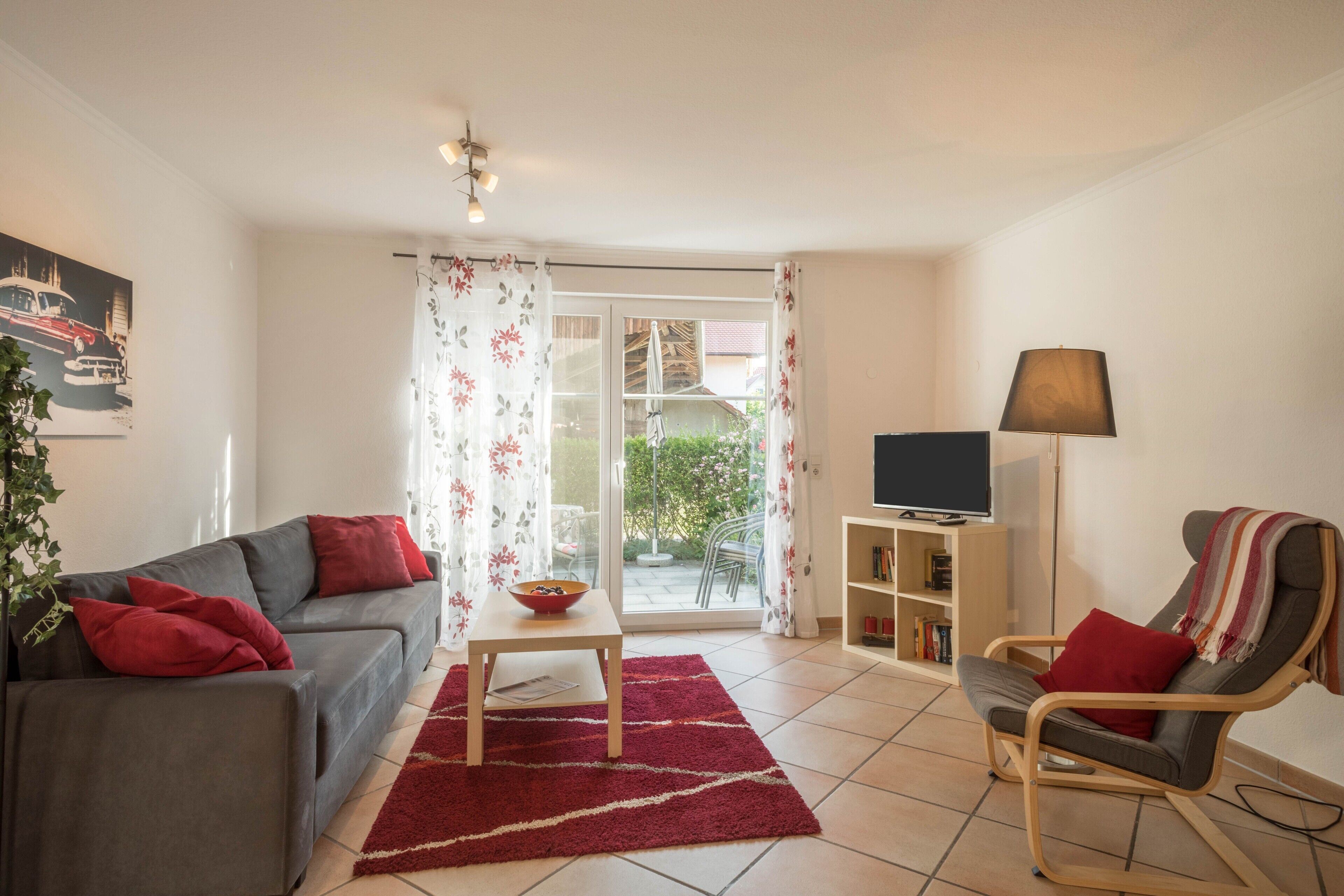 Un salon comprenant un canapé, un fauteuil, une table et un meuble pour la télévision.