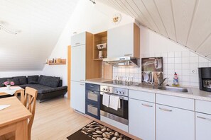 Kompakti keittiö, jossa on sisäänrakennettu uuni, liesi ja pesuallas.