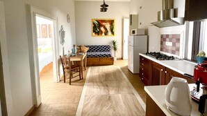 Une cuisine compacte comprenant un coin repas, un réfrigérateur, un four à micro-ondes et une cuisinière.