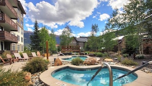Ein Resort mit Whirlpoolbereich, Liegestühlen und Pool.