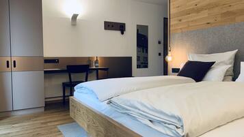 Una habitación de hotel moderna con una cama de madera, un escritorio y un armario.