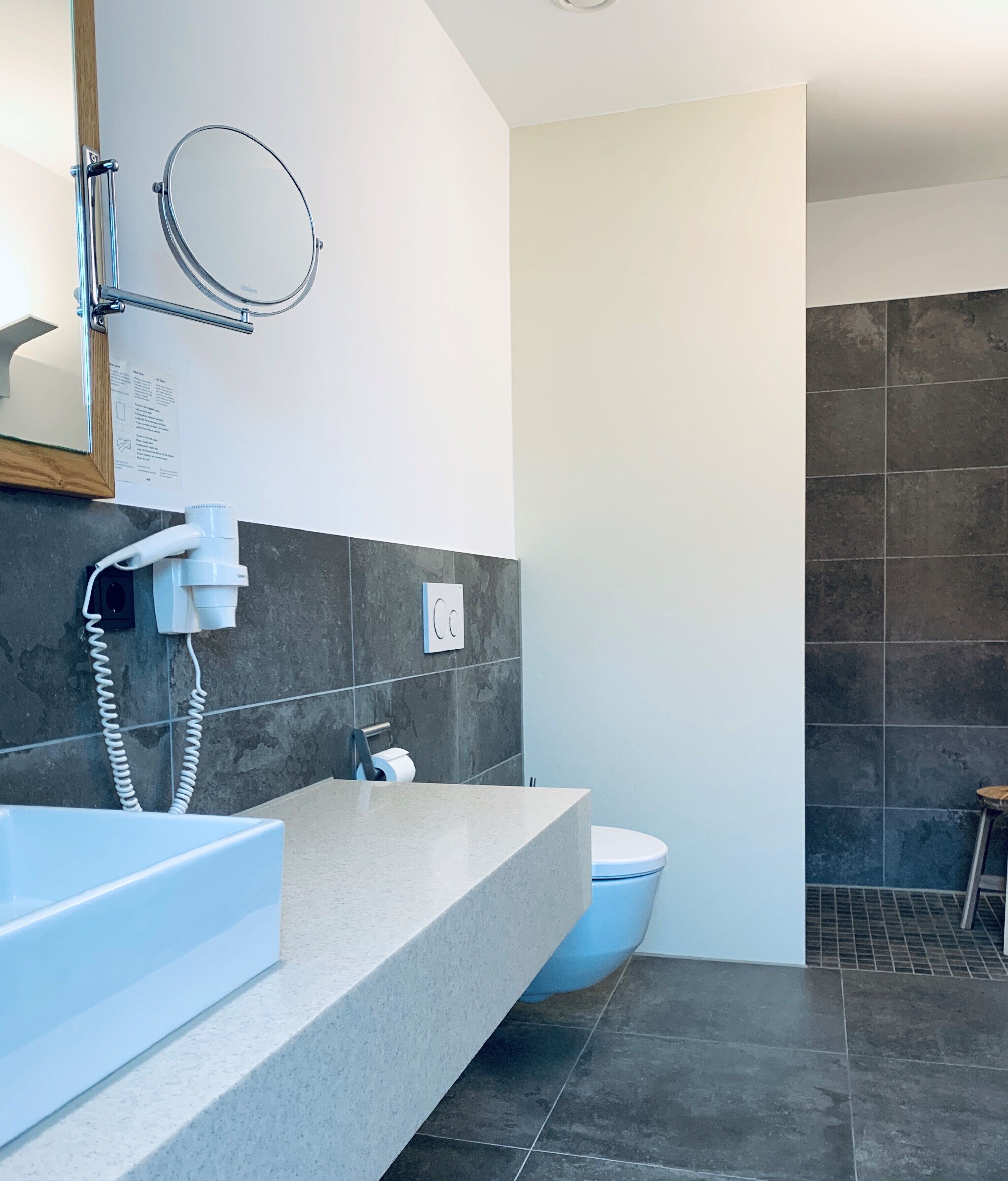 Une salle de bain moderne avec un grand lavabo, des toilettes et un espace douche.