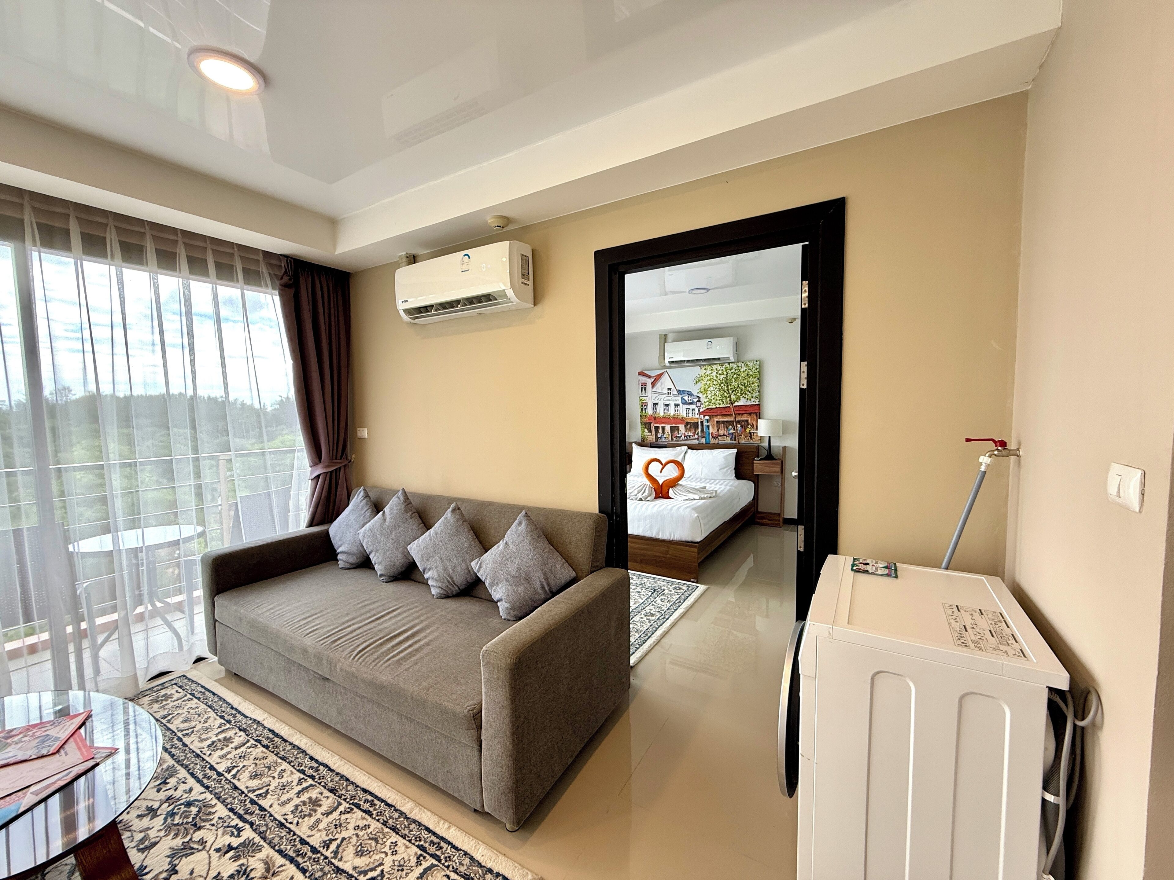 A modern living room with a grey sofa, a round coffee table, and a patterned rug.