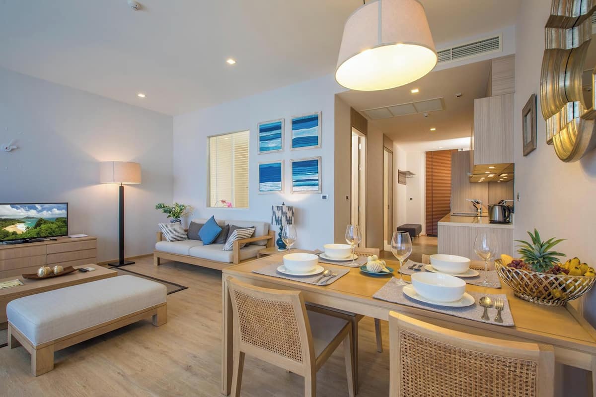 A modern living room with a sofa, dining table, and a TV.