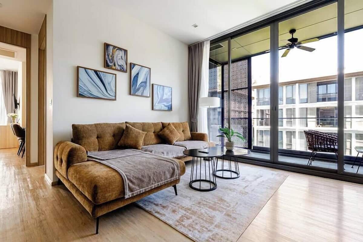 A modern living room with a sofa, a coffee table, and artwork on the wall.