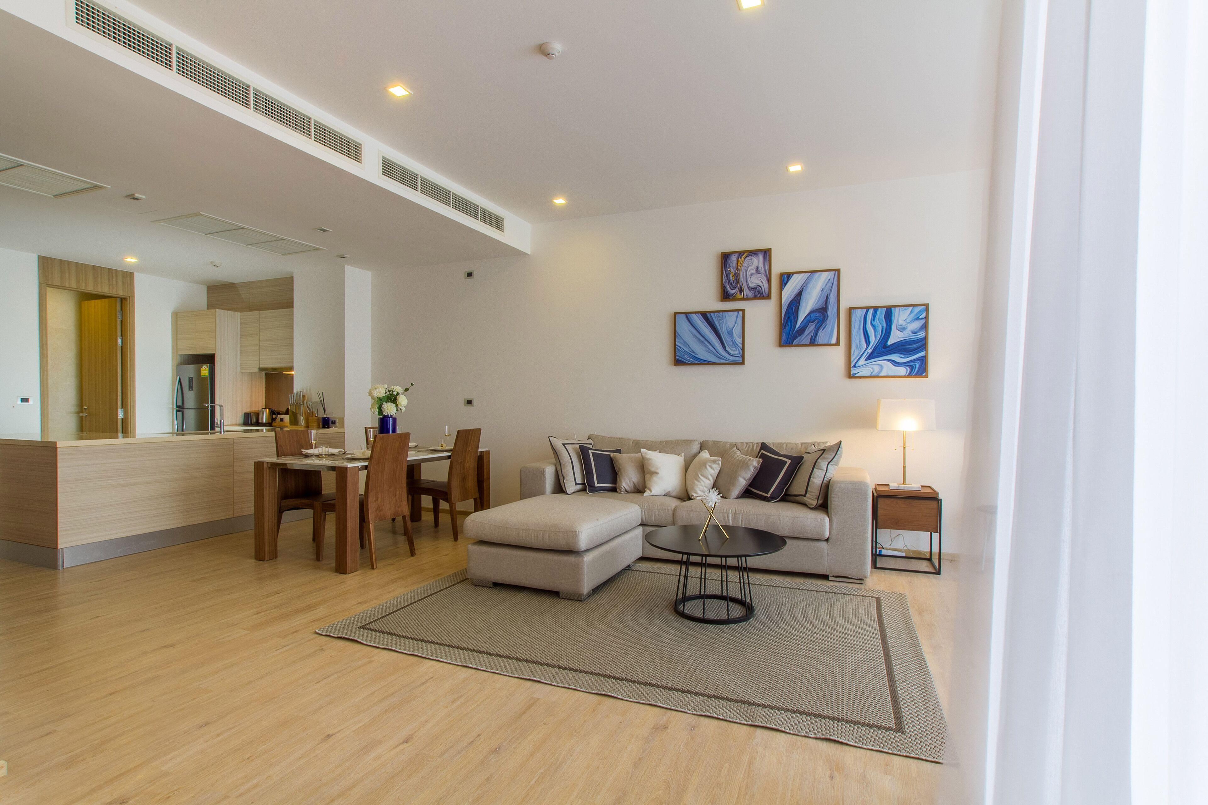 Uma sala de estar moderna com sofá, mesa de centro e área de jantar.