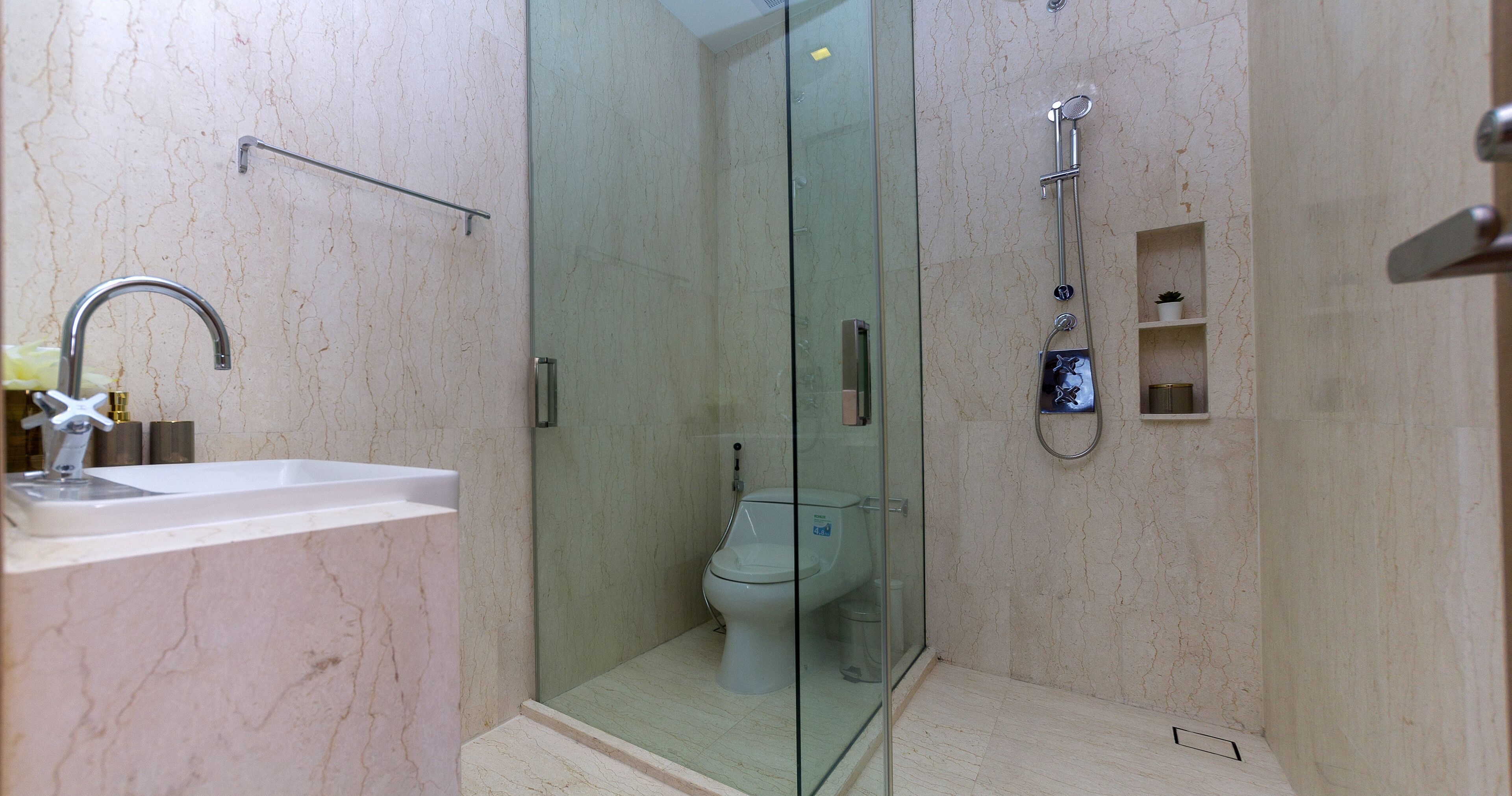 Une salle de bain moderne avec une douche à parois de verre, un lavabo et des toilettes.