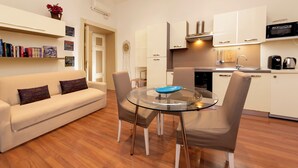 A modern kitchen with white cabinets, a microwave, and a coffee maker. - Babuino Apartments - Piazza di Spagna (Rome)