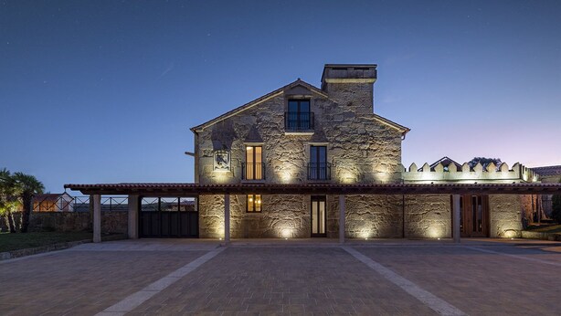 A large stone house with a covered patio and multiple windows, illuminated at night. - EXCLUSIVE RURAL HOUSE WITH POOL IN LAS RIAS BAIXAS  (MEIS)