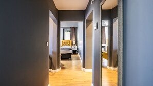 A hallway with a bed, bedside table, and a mirror. - Selvese Suites – Serviced Living in Galata (Istanbul)