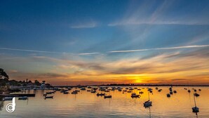 A sunset over a calm harbor with numerous boats anchored, reflecting the sky's colors. - Vacations for 6 around the Gulf (Saint-Gildas-de-Rhuys)