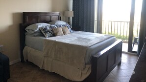A bedroom with a bed, a ceiling fan, a window with curtains, and a view of the outdoors. - Walk To The Beach From This Beautifull New Studio With Everything You Need (St. Thomas)