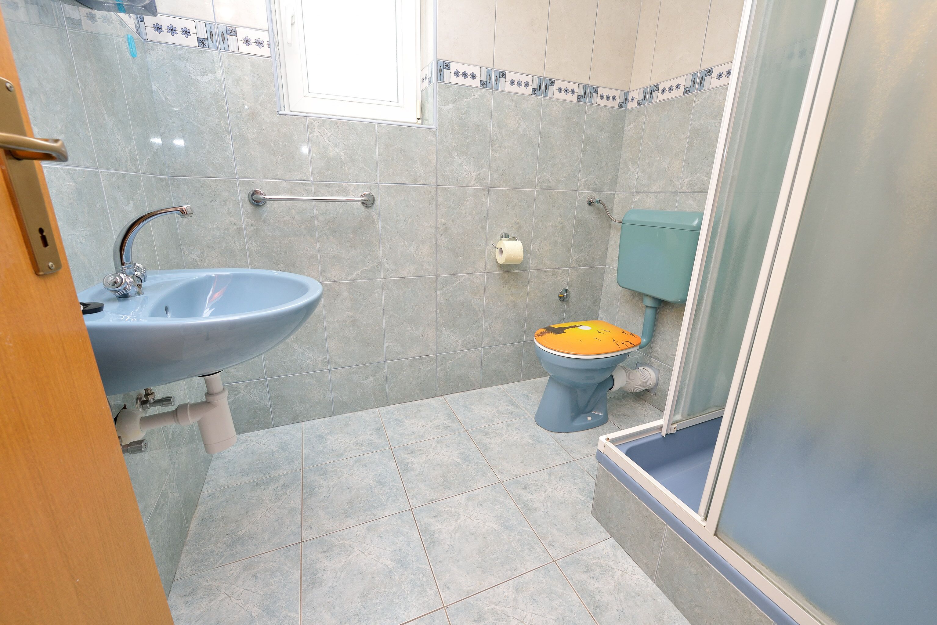 Un bagno con lavandino, WC e doccia.