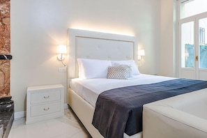 Une chambre à coucher avec un lit, des tables de chevet et une fenêtre.