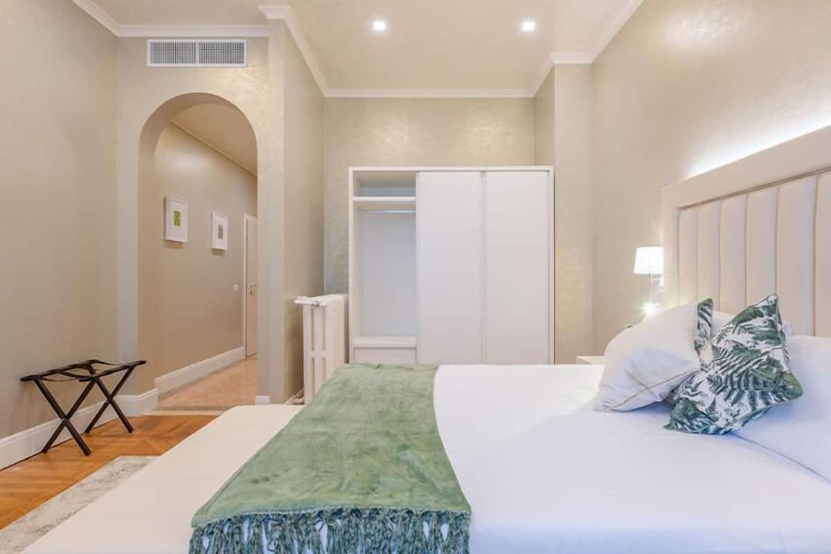 Een slaapkamer met een bed, een kast en een radiator.