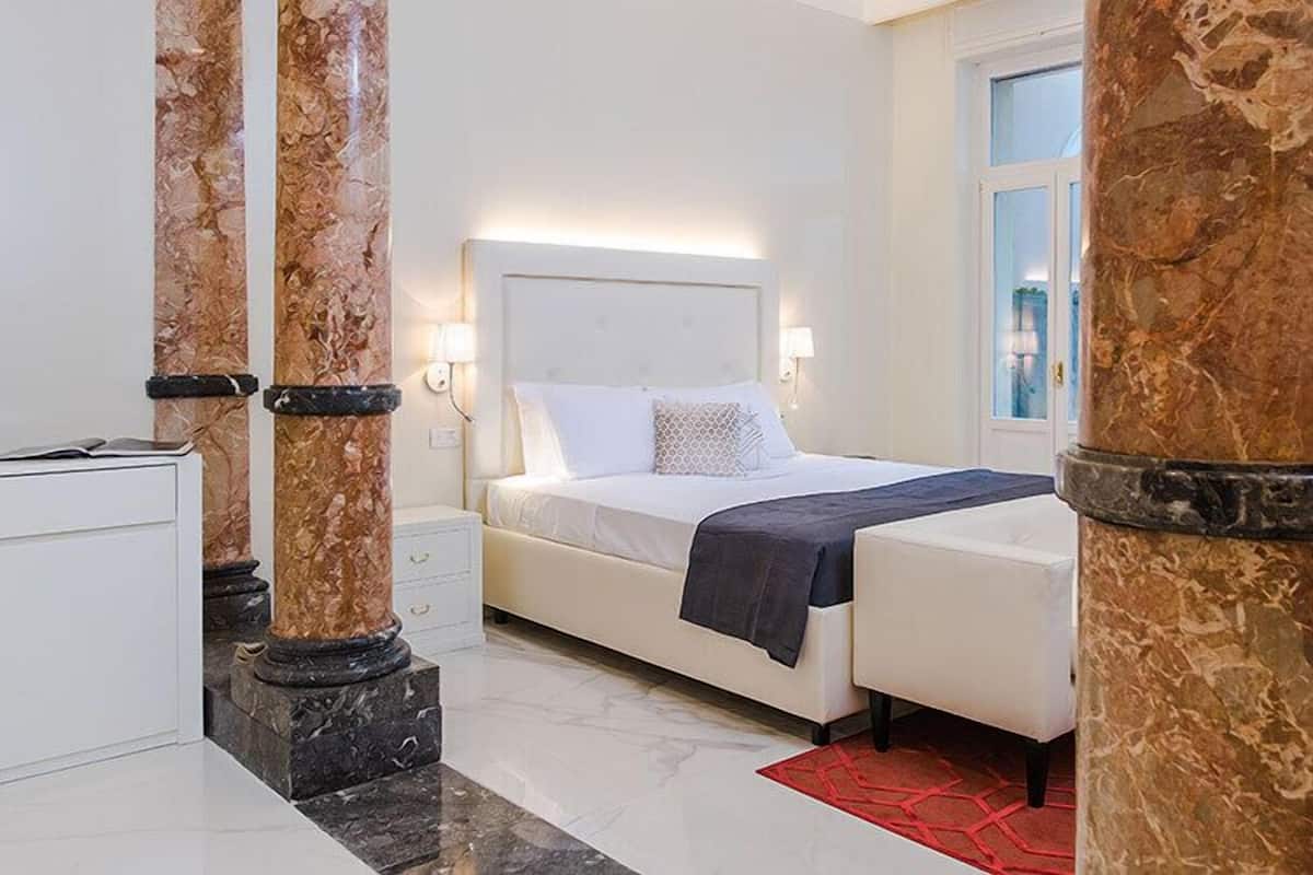 Een slaapkamer met een bed, nachtkastjes en een raam.