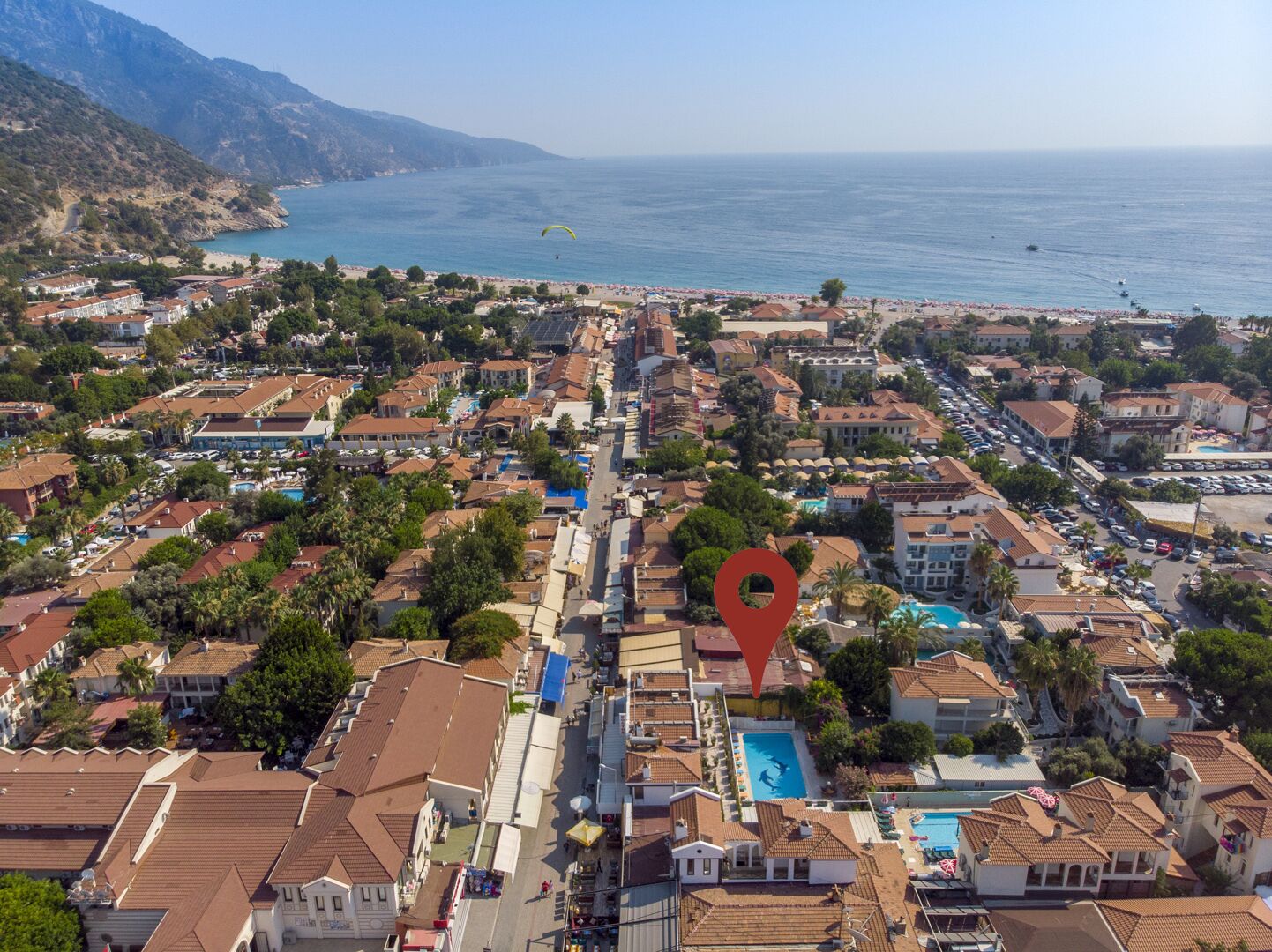 A coastal town with a mix of residential and commercial buildings, a beach, and a view of the sea.