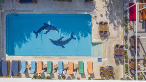 An aerial view of a swimming pool with dolphin-shaped tiles, surrounded by lounge chairs and tables. - On Oda Oludeniz (Fethiye)
