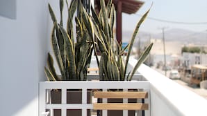 A balcony with a white railing, a wooden bench, and a potted plant. - Vorta Naxos - Adults Only (Naxos)