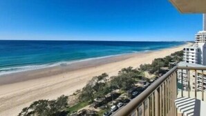 A beachfront hotel with a view of the ocean and beach.