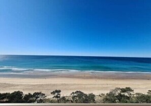 Enjoy breathtaking ocean views from a balcony overlooking the wide, sandy beach.