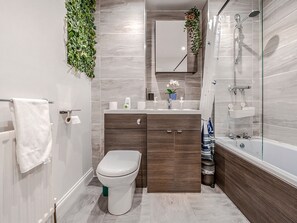 Banheira, secador de cabelo, toalhas de banho, shampoo