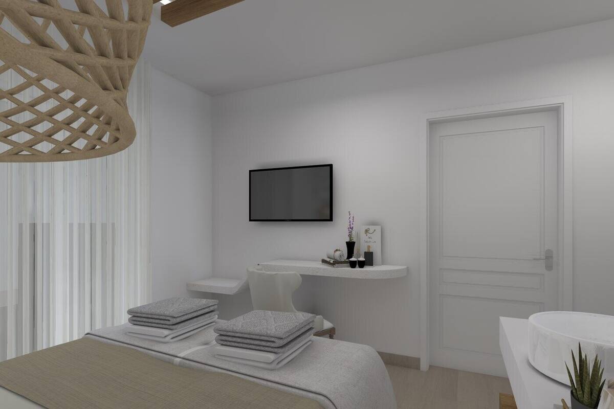 A modern bedroom with a bed, bedside tables, a TV, and a door.
