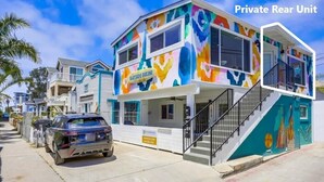 Un edificio colorido de dos pisos con un letrero que dice "BAYSIDE BIKINI".