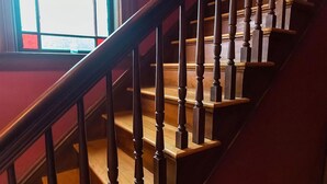 A wooden staircase with a handrail and balusters, leading to an upper floor. - Your Beautiful Victorian Getaway (Bethel)