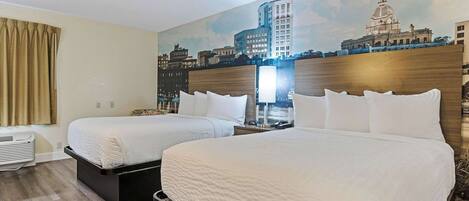 A hotel room with two beds, a cityscape mural, a nightstand, and a window with curtains.
