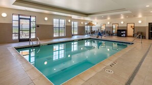An indoor swimming pool with clear water, tiled flooring, and a sunlit area with tables and chairs. - Comfort Suites Broomfield-Boulder/Interlocken (Broomfield)