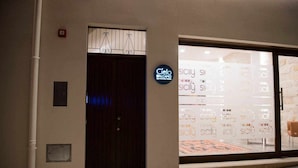 A hotel entrance with a dark wooden door, a large window displaying the word "Cielo" and "Sicily" repeatedly, and a sign indicating "Cielo Alcampo". - Rosa Fresca Aulentissima (Alcamo)