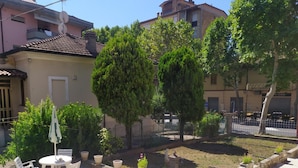 A courtyard with a round table and chairs, surrounded by potted plants and a small fountain. - Bed & Breakfast Domus Cesena (Cesena)