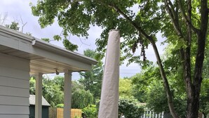 An outdoor patio with a round table and chairs, a covered umbrella, and a brick floor. - HOT TUB Columbus Indiana  (Columbus)
