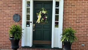 A brick house with a green door, number 4016, a welcome sign, a wreath, and two potted plants. - HOT TUB Columbus Indiana  (Columbus)