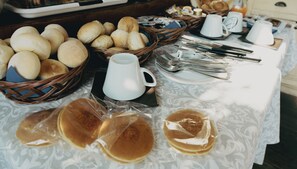 Un buffet de petit-déjeuner proposant un assortiment de pains, de viennoiseries et de crêpes.