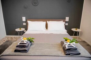 A neatly made double bed with white linens, two side tables with lamps, and a small potted plant on each table. - Cielo D'Alcamo center - Jester (Alcamo)
