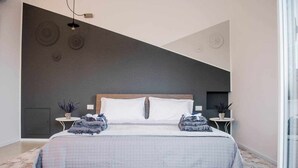 A modern bedroom with a large bed, two bedside tables, and a dark accent wall. - Cielo D'Alcamo center - Cielo (Alcamo)