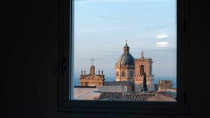 A view through a window of a building with a prominent dome and a bell tower. - Cielo D'Alcamo center - Cielo (Alcamo)