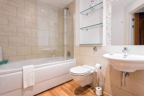 A modern bathroom with a bathtub, toilet, and sink. - Steep Holm - With Spacious Balcony (Poole)