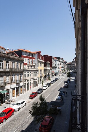Une vue de rue avec des immeubles, des voitures garées et un ciel dégagé.
